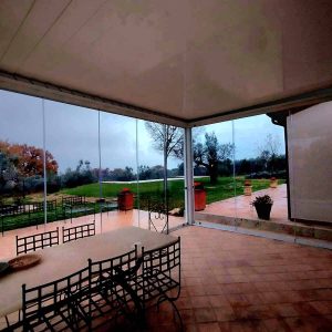 Veranda con tavolo e sedie, vista giardino.