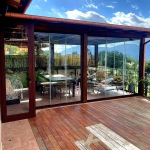 Terrazza con tavolo e vetrate trasparenti.