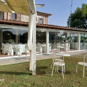 Tavoli e sedie all'aperto, veranda vetrata.