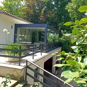 Terrazza moderna con vetrate e piante.