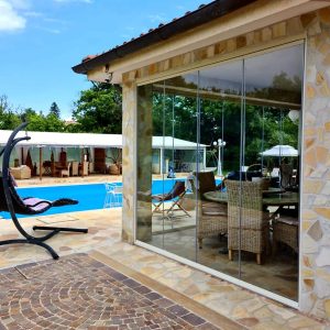 Terrazza con piscina e sedie a dondolo.
