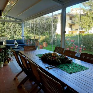 Veranda con tavolo e sedie in legno.