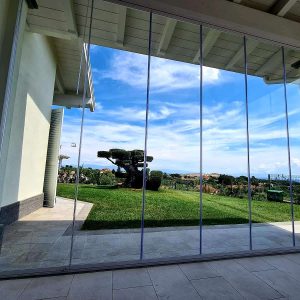 Vista su giardino attraverso vetrata trasparente.