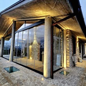 Casa moderna con ampie vetrate illuminate.